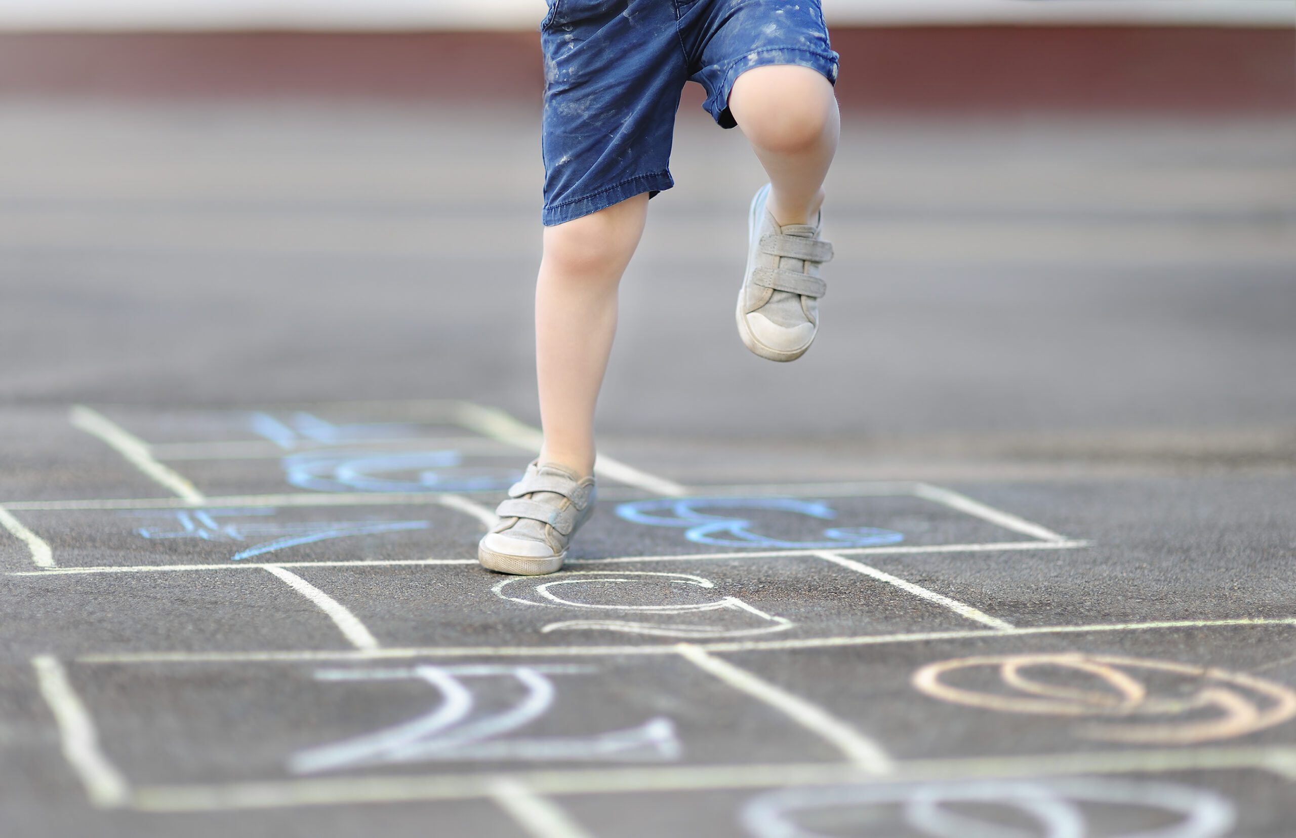 Closeup of young boys legs playing hopscotch