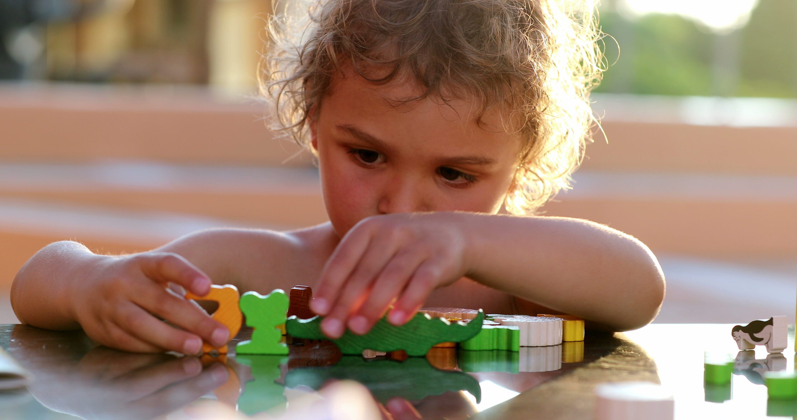 Young boy playing with toys on table outside