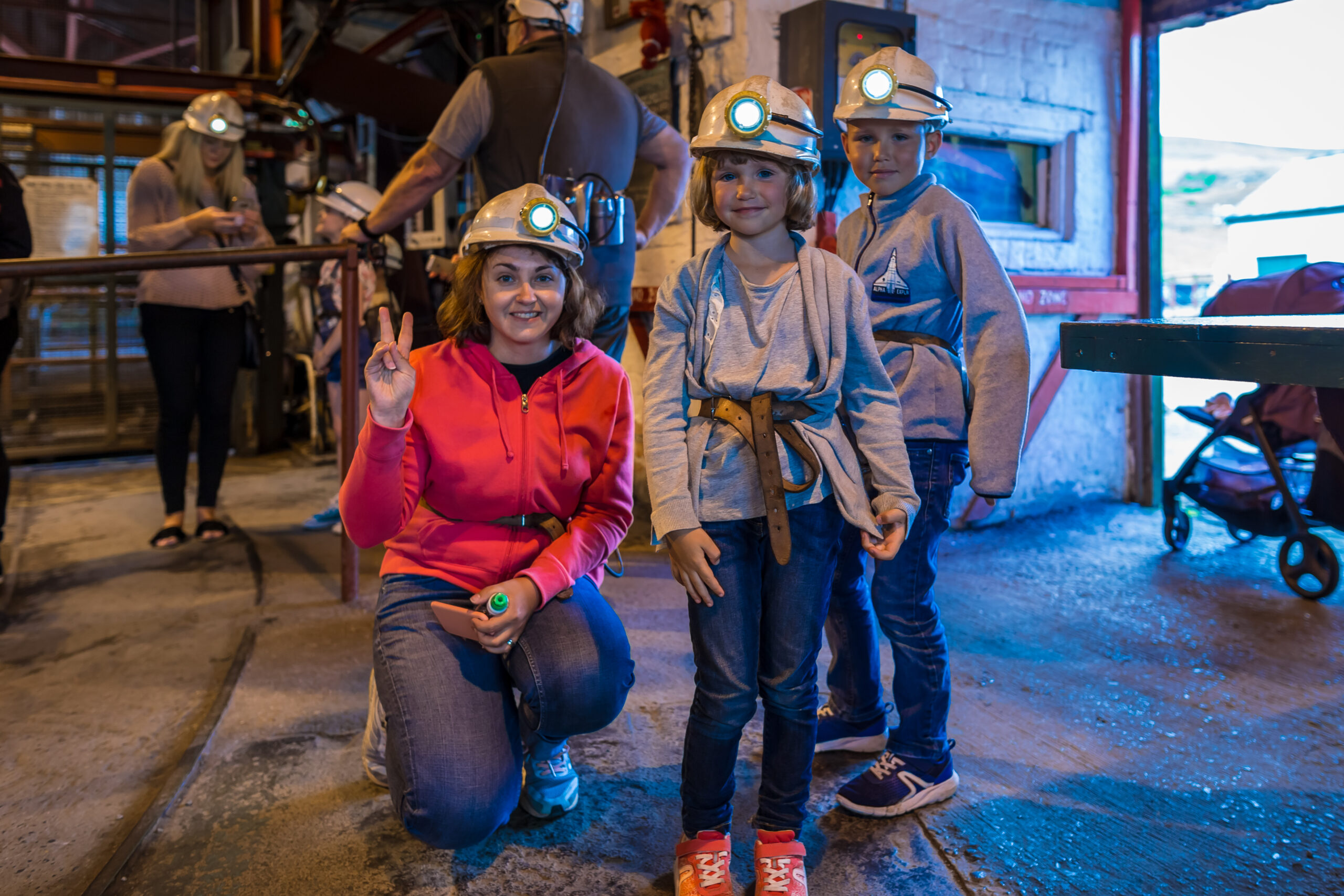 foster family visiting welsh coal mine wearing mining equipment