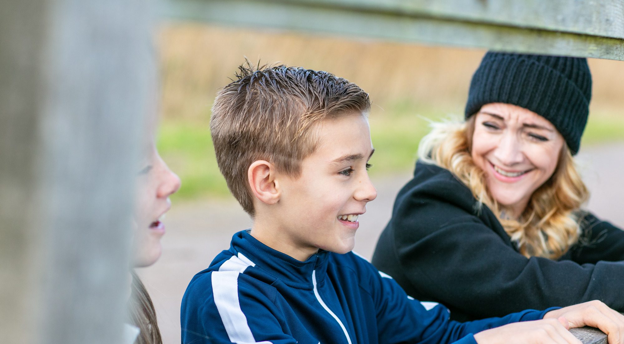female foster carer laughing with young boy and girl