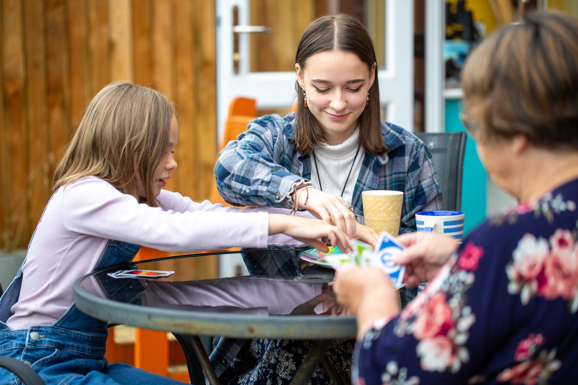 woman and girl having coffee playing uno